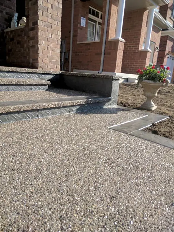Aggregate entrance and stairs alongside brick and stone garden walls
