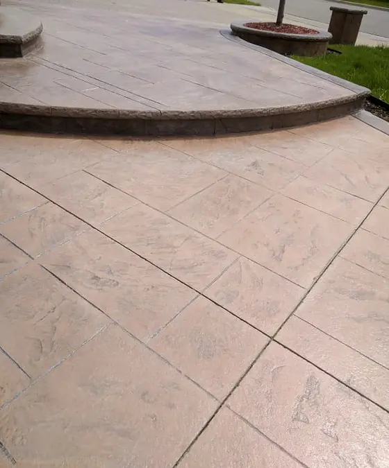 Warm-toned stamped concrete at the base of curved entrance steps