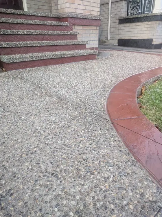 Curved exposed aggregate surface with a red accent border
