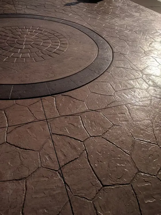 Brown stamped concrete with a curved decorative border